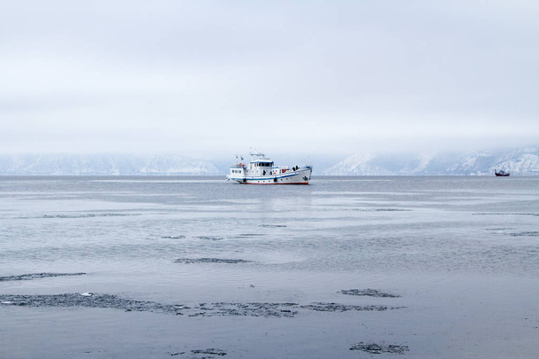 ship sailing on a freezing Baikal among ice floes - Фото, изображение