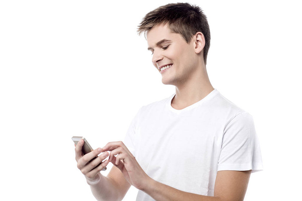 Casual boy reading sms on his mobile - Zdjęcie, obraz