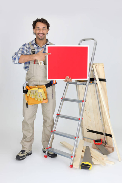 woodworker holding a painted ad board - Fotoğraf, Görsel