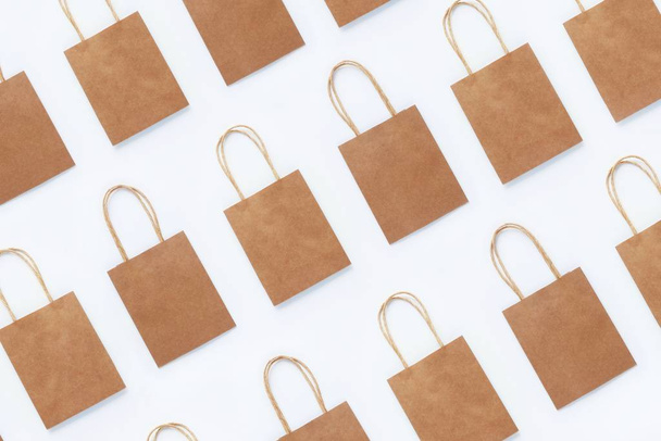 Seamless photo pattern of brown craft packaging bags for shopping on a white background. Concept of zero waste, reasonable consumption, recycling, discounts. Top view, flat lay. - Fotoğraf, Görsel