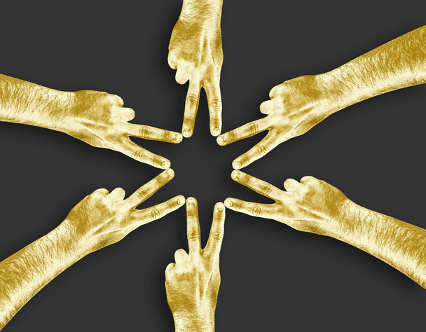 Gold Hand vingers gestapeld om sterrenbeeld op lichte achtergrond. Bedrijfsconcept, samenwerking. Gouden vingers raken elkaar en maken een ster symbool. - Foto, afbeelding