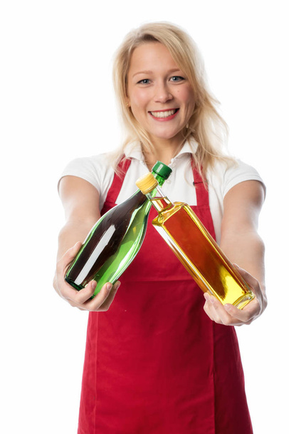 woman with apron presenting a bottle of oil and vinegar - Foto, Imagem