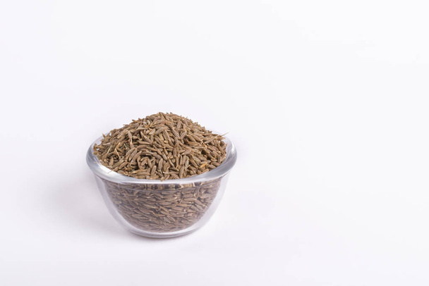 Cumin seeds in a glass bowl on white - Foto, Imagen