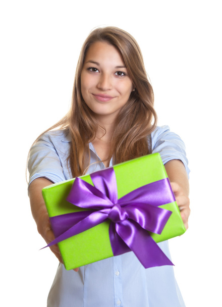 Smiling young woman showing a christmas gift - Foto, Bild