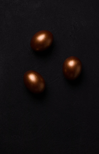 Huevos de Pascua sobre fondo negro. Concepto de minimalismo
 - Foto, imagen