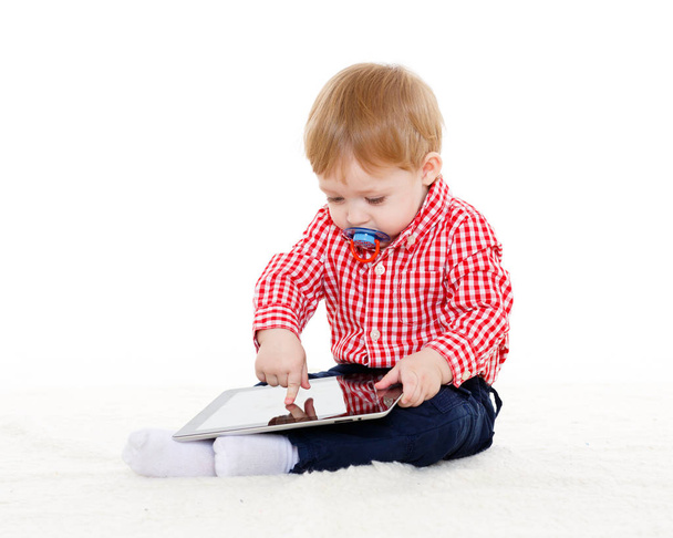 Małe słodkie dziecko bawi się komputerową tabletką na białym tle. Nauka zabawek i wczesny rozwój. - Zdjęcie, obraz