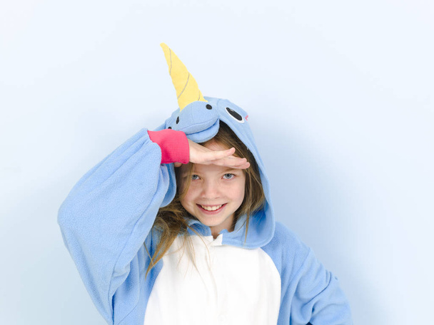 happy pretty blonde girl in cozy unicorn costume in studio on blue background  - Valokuva, kuva