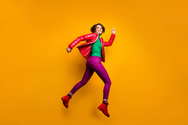 Full size profile photo of funny lady jumping high rushing shopping discount prices wear casual red overcoat trousers turtleneck boots isolated yellow color background - Φωτογραφία, εικόνα