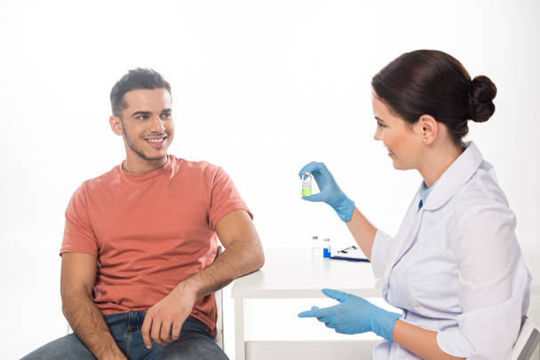 Médecin souriant montrant le vaccin au patient isolé sur blanc
 - Photo, image