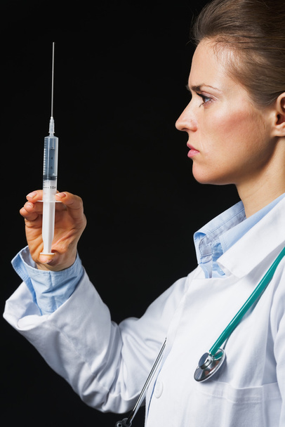 Doctor woman with syringe on black background - Fotó, kép