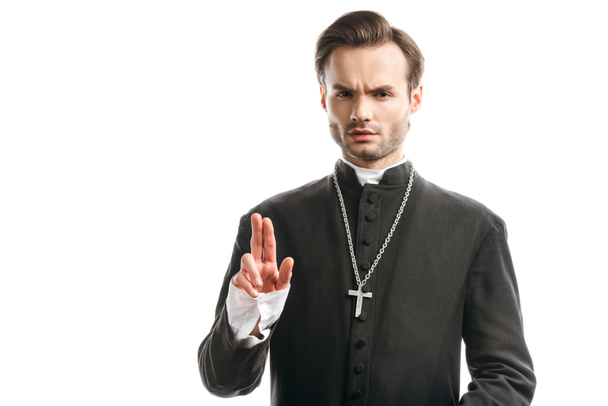 уверенный, строгий католический священник показывает жест благословения изолированы на белом
 - Фото, изображение