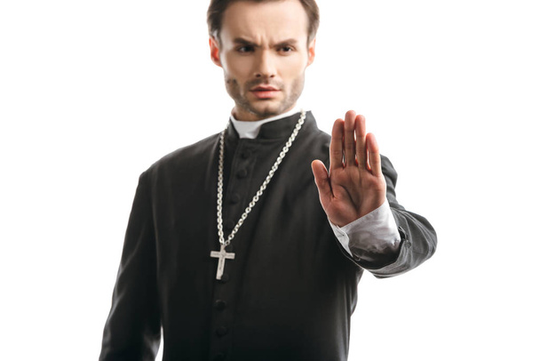 selective focus of serious, strict catholic priest showing stop gesture isolated on white - Fotoğraf, Görsel