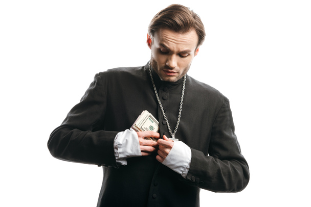 жадный католический священник, прячущий деньги в рясе, изолированном на белом
 - Фото, изображение