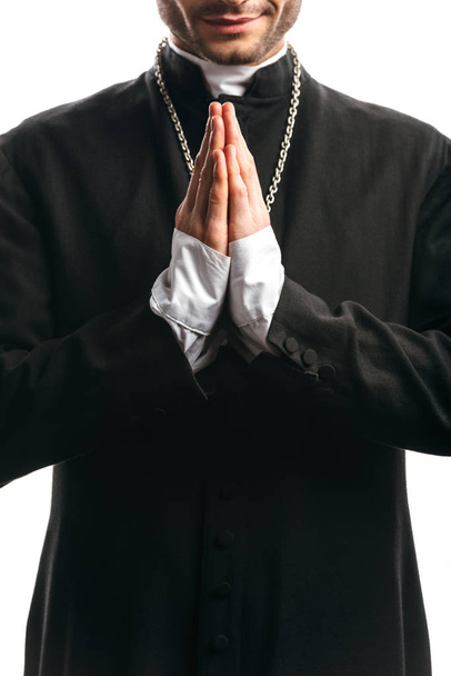 partial view of catholic priest in black cassock praying isolated on white - Zdjęcie, obraz