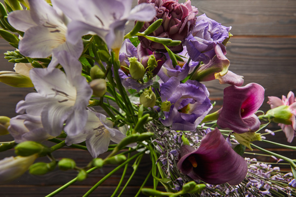 木のテーブルの上に紫色と紫色の花花束の選択的な焦点 - 写真・画像