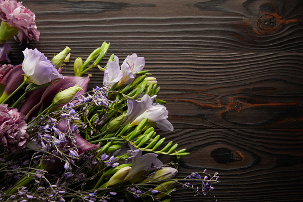 top view of violet and purple floral bouquet on wooden table - Foto, Imagem