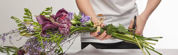 cropped view of florist cut violet bouquet with scissors isolated on white, panoramic shot - Zdjęcie, obraz