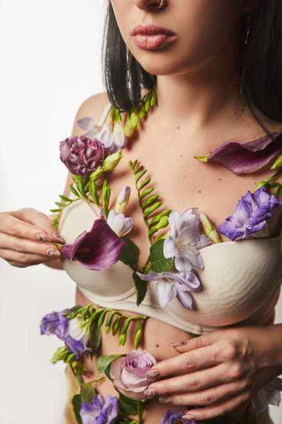 cropped view of girl in bra with violet and purple flowers on body isolated on white - Фото, зображення