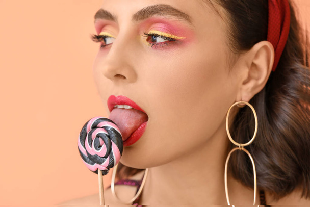 Beautiful young woman with lollipop on color background, closeup - Fotó, kép