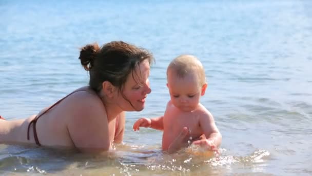 μητέρα με το μωρό που παίζει στη θάλασσα - Πλάνα, βίντεο