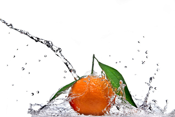 Tangerine with green leaves and water splash - Fotó, kép