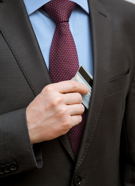 επιχειρηματίας, βάζοντας μια πιστωτική κάρτα σε μια τσέπη - Φωτογραφία, εικόνα