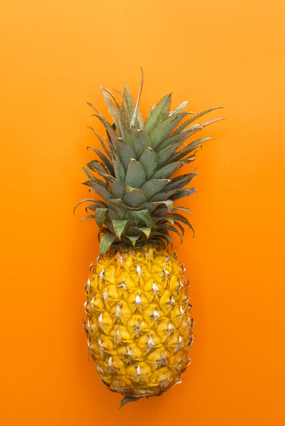 Pineapple, yellow ripe fresh tropical exotic fruit isolated on yellow orange background. One whole ananas. Healthy vegan or vegetarian food. Vertical photo. - Photo, Image