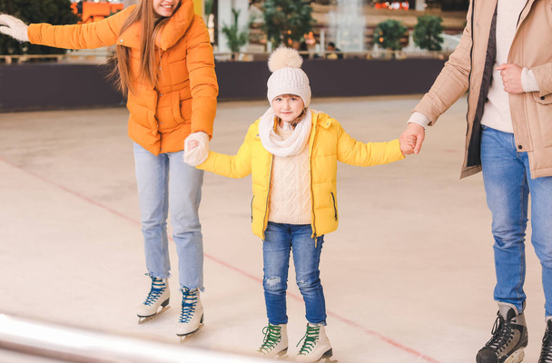 Família feliz no ringue de patinação
 - Foto, Imagem