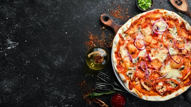 Homemade pizza on a black stone background. Italian cuisine. Top view. Free space for your text. - Foto, Imagem