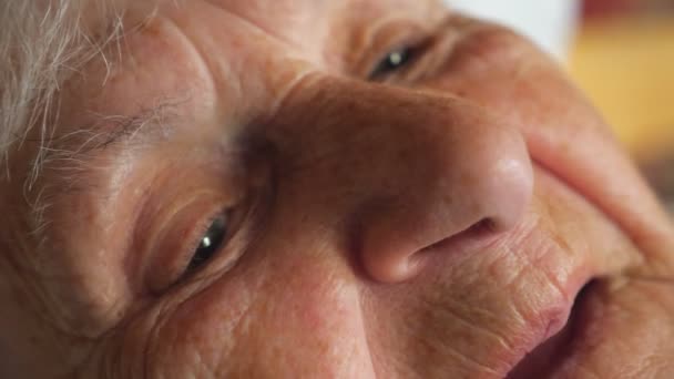 Retrato de uma mulher idosa a ver algo pensativo. Close-up de cara velha fêmea da avó com rugas. Visualização de detalhes em câmera lenta
 - Filmagem, Vídeo