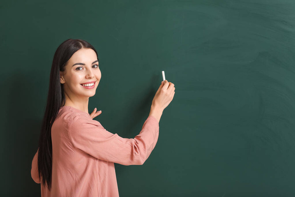 Nainen opettaja kirjallisesti blackboard luokkahuoneessa
 - Valokuva, kuva