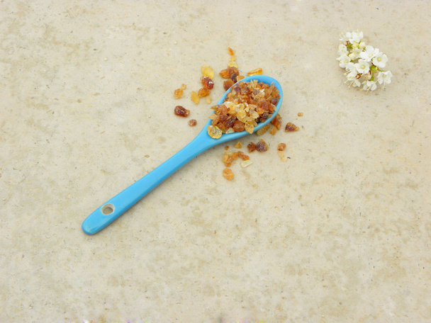  candys, azúcar caramelizada (caramelo) en una cuchara azul sobre un fondo claro
                               - Foto, Imagen