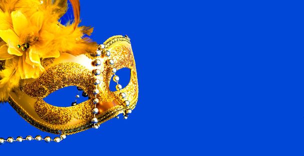 Carnival mask on blue background with silver beads. Mardi Gras concept. Copy space - Photo, Image