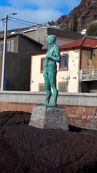El pueblo de Paul Do Mar en la isla de Madeira. La estatua se llama 'O homem Do Mar', 'Hombre del Mar' .Paul do Mar situado junto al mar al suroeste de Madeira, un pueblo pesquero tradicional y un punto caliente de surf con la estatua del Hombre del Mar
 - Foto, imagen