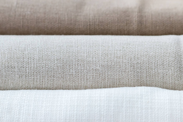 Fundo textural horizontal de três tipos de tecido de linho natural, enrolados. Foco seletivo. Vista de perto
 - Foto, Imagem