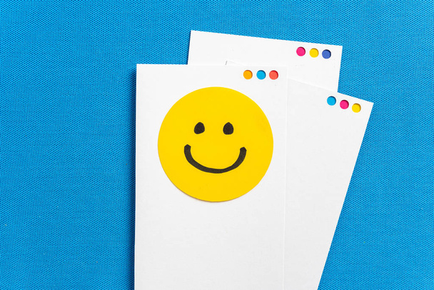 Σημειώσεις με κίτρινο κύκλο χαρούμενο χαμογελαστό πρόσωπο κινουμένων σχεδίων σε χαρτί scr - Φωτογραφία, εικόνα