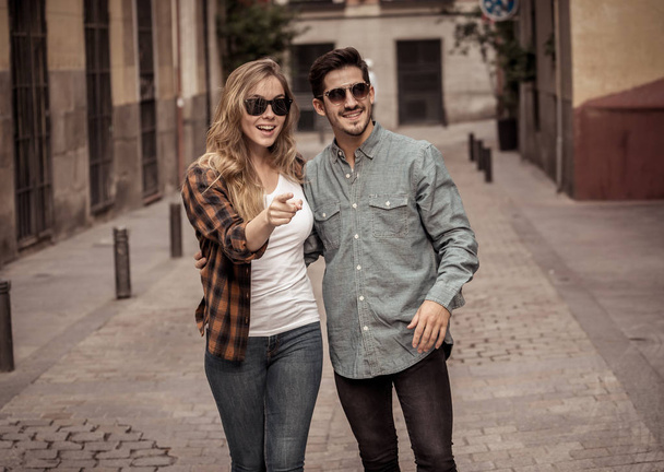 Young couple in love walking on street holding hands having fun traveling around Europe on vacation in a romantic trip or city break. In tourism, lifestyle and travel concept. - Zdjęcie, obraz