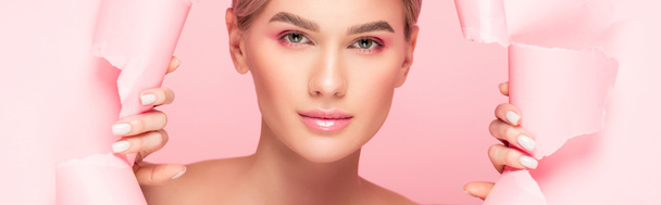 plano panorámico de tierna mujer con maquillaje rosa en papel roto, aislado en rosa
 - Foto, Imagen