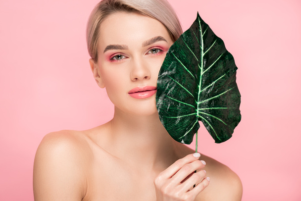 naked girl with pink makeup isolated on pink with green leaf - Fotografie, Obrázek