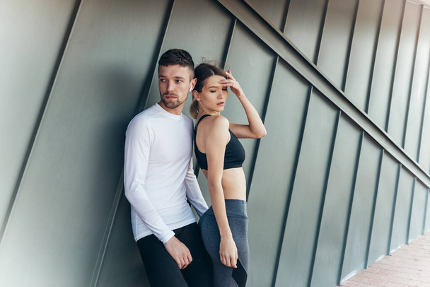 Fitness couple standing outdoors. Sport, workout, healthy lifestyle concept. - 写真・画像