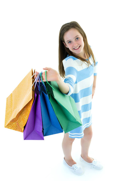 Teenager girl shopping in a store with large paper bags. - Foto, immagini