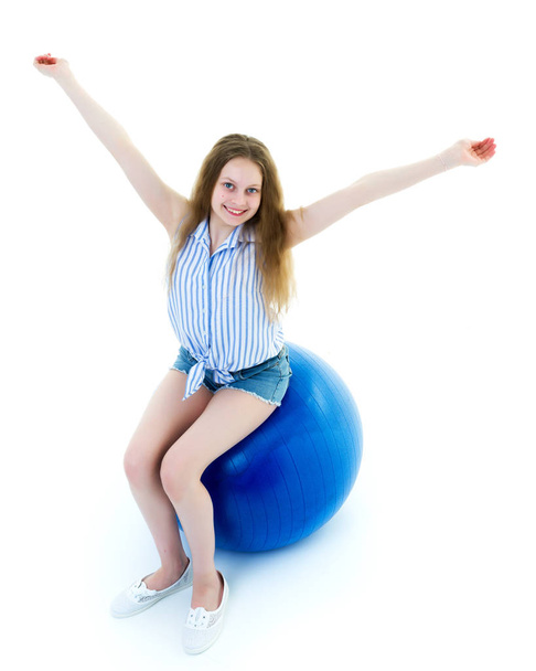 little girl doing exercises on a big ball for fitness. - Фото, зображення