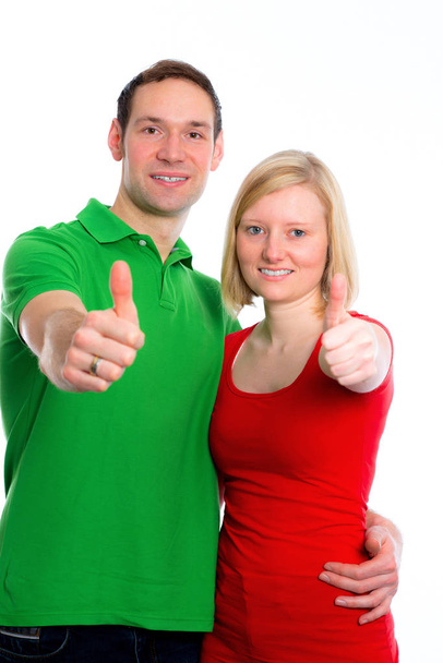young happy couple in front of white background with hands with thumbs up - Photo, image