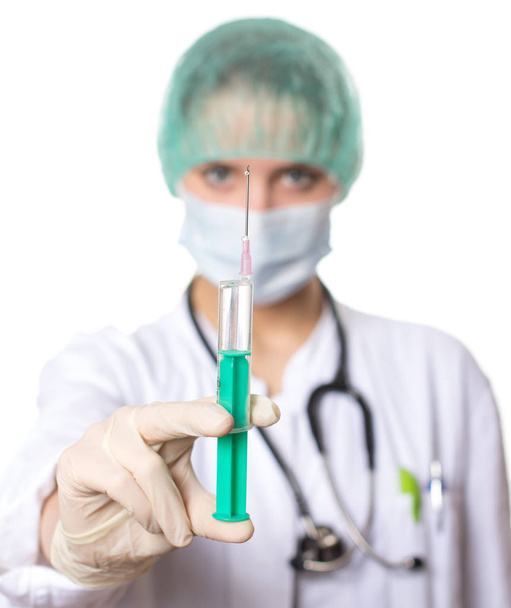female doctor holding a syringe, selective focus on the hand holding the syringe - Photo, image