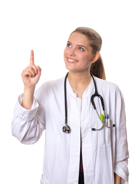 female doctor in a white coat looking up and pointing up with her index finger - Foto, immagini