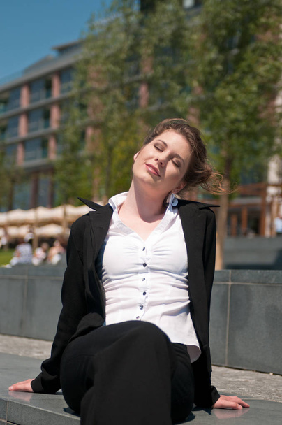 Young business woman with face turned to sun - relax during lunch break - Zdjęcie, obraz
