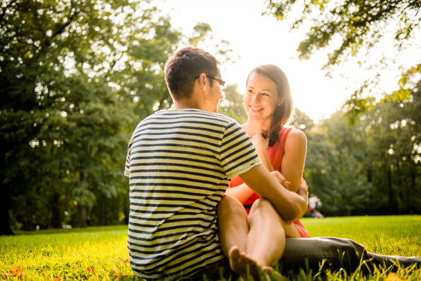 Junges Paar beim Dating und Umarmen in der Natur - geschossen gegen die direkte Sonne - Foto, Bild