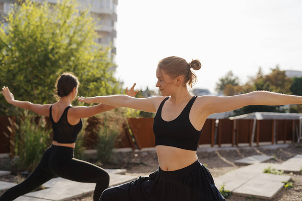 Dwie młode dziewczyny ćwiczące rozciąganie i ćwiczenia jogi razem - Zdjęcie, obraz