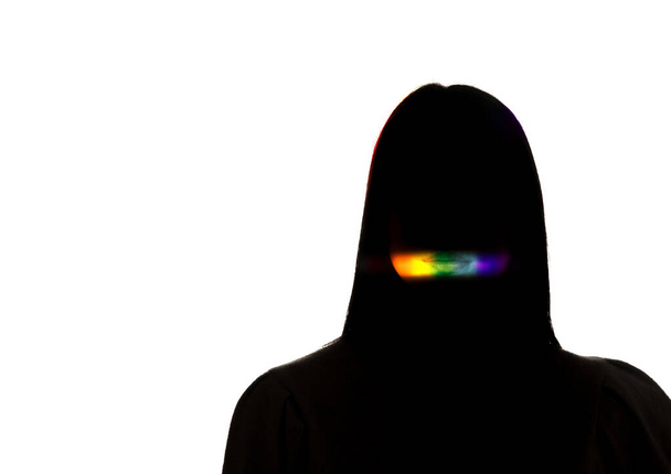 Dramatic portrait of a girl in the dark on white studio background with rainbow colored line - 写真・画像