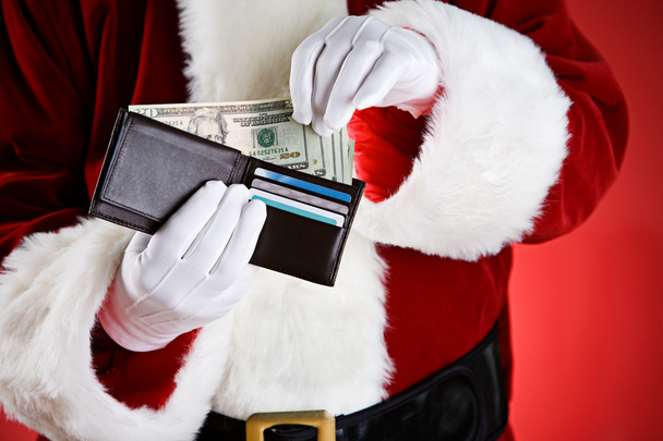 Santa: Pulling Cash Out Of Wallet - Foto, immagini